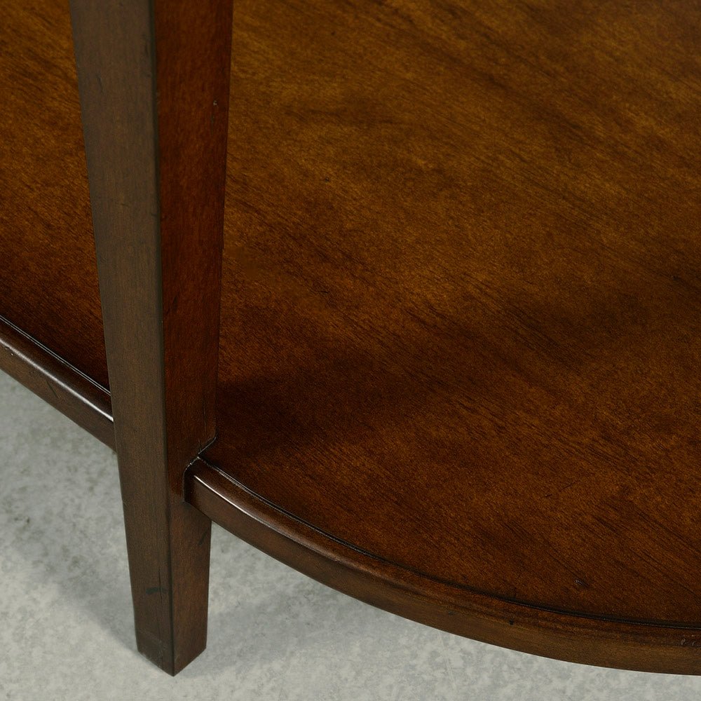 Dark wood console table lower shelf close-up.