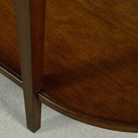 Dark wood console table lower shelf close-up.