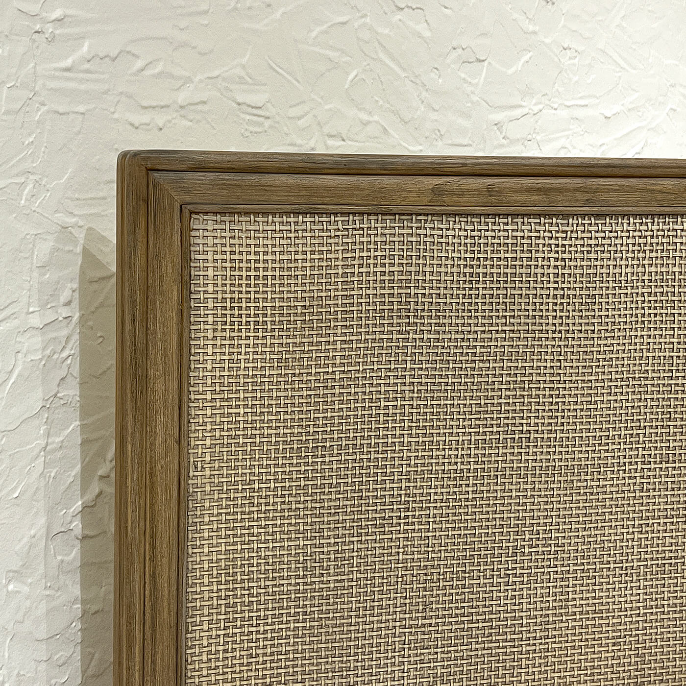 Close-up of bed's woven headboard detail.