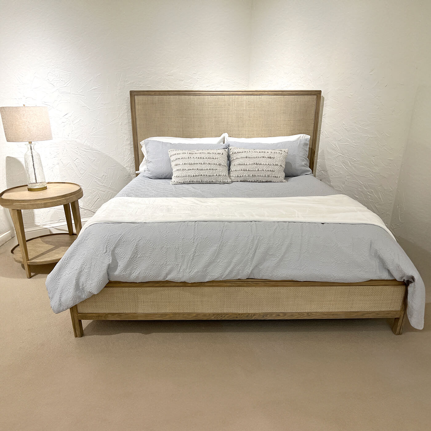 Front view of modern bed with pillows and blanket.