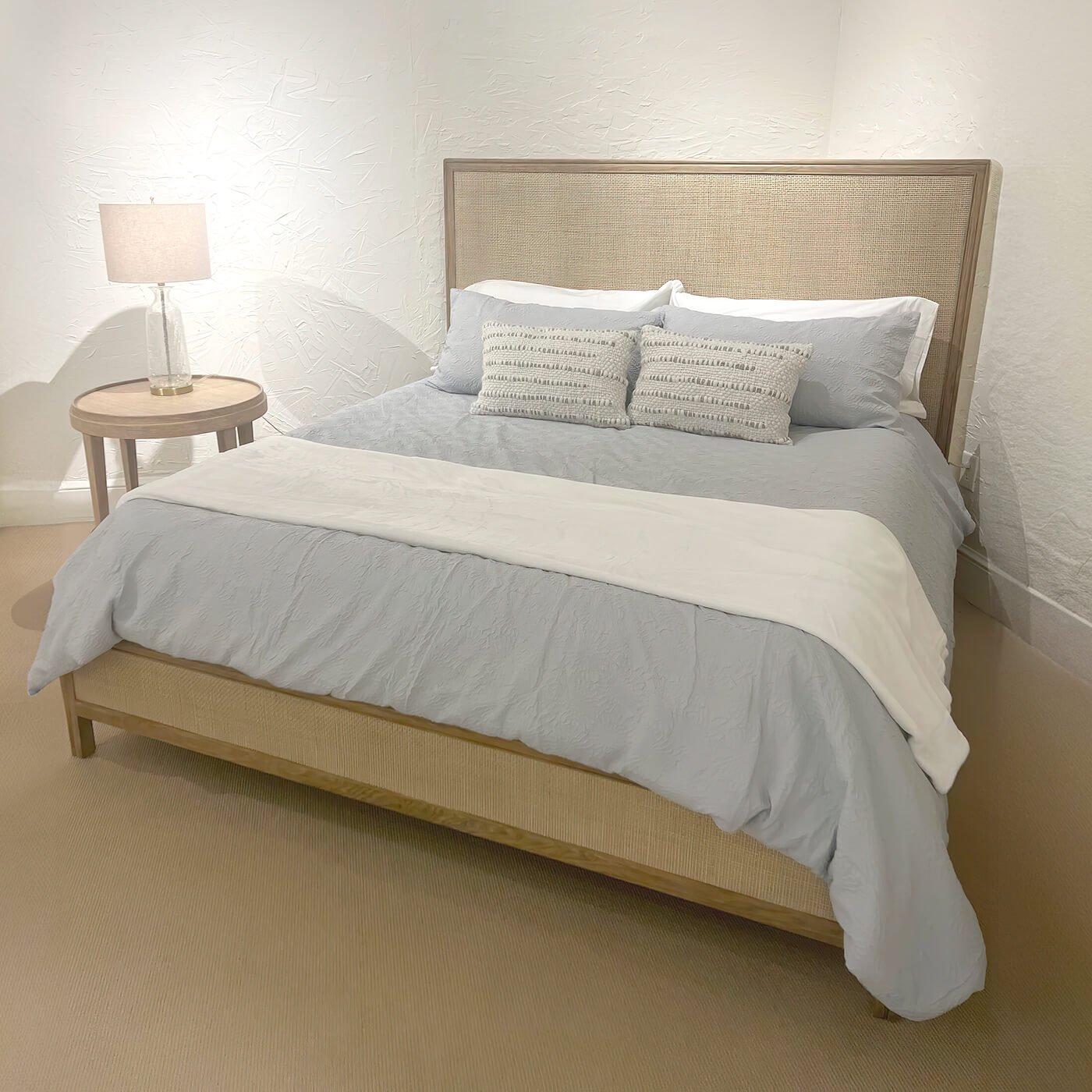 Bedroom with bed, side table, and lamp setup.