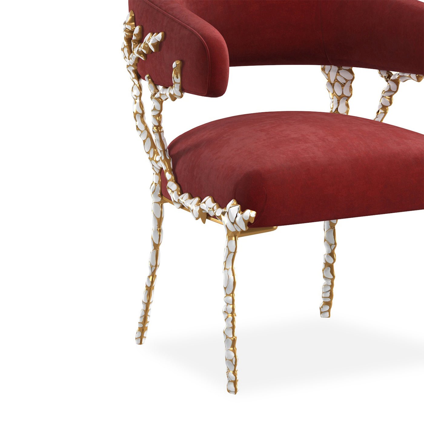 Red velvet chair with ornate frame, partial side view.