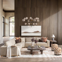 Beige sectional styled in a wood-paneled living room with pillows, a throw and a coffee table