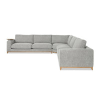 Front-angle view of gray sectional showing the long seating run, square arm and wood base