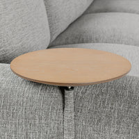 Close-up of the round wood table beside the gray sectional arm and seat cushion