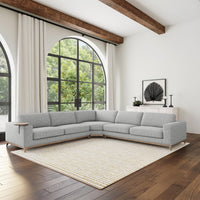 Gray sectional styled in a bright living room with arched windows and a pale woven rug