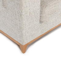 Close-up of sand sectional arm, exposed oak wood base and tapered foot