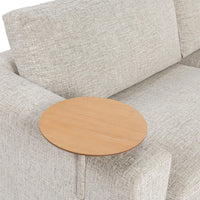 Close-up of the round wood table at the sand sectional arm beside a back cushion