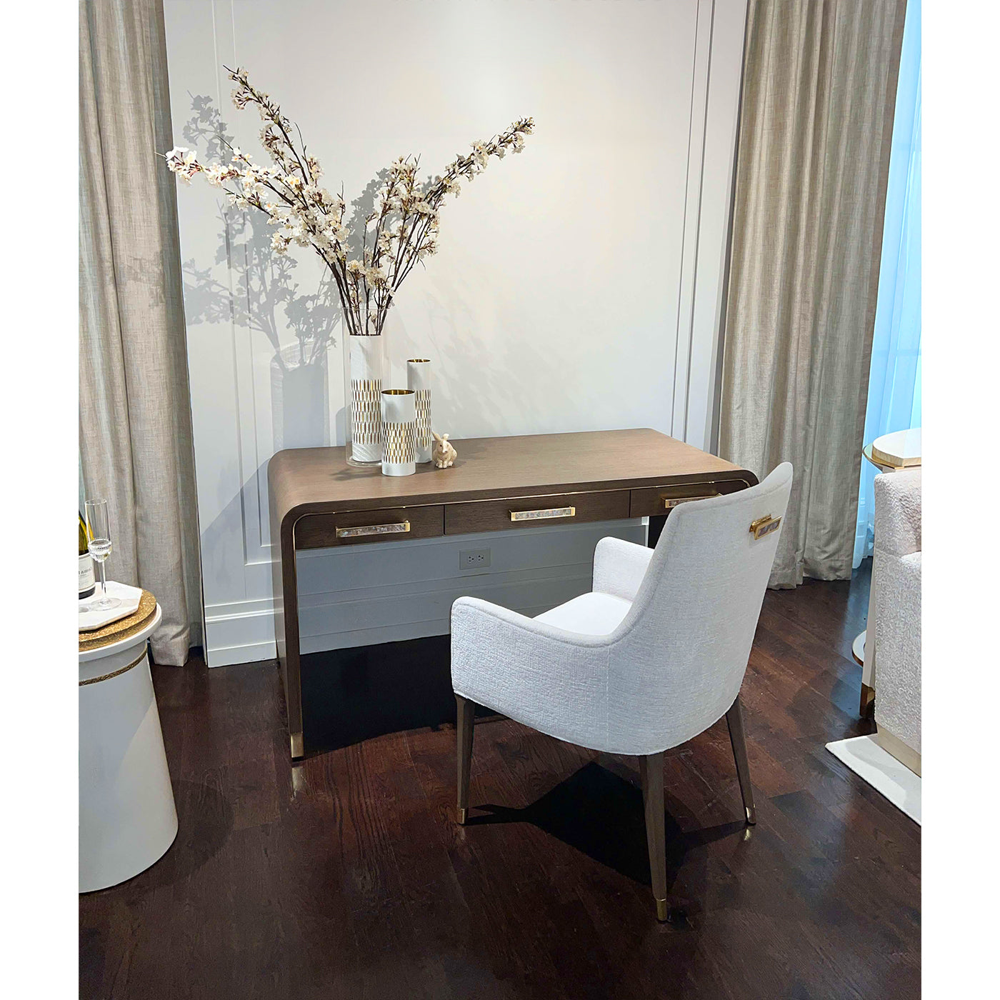 Desk in room setting with chair and decorative items.