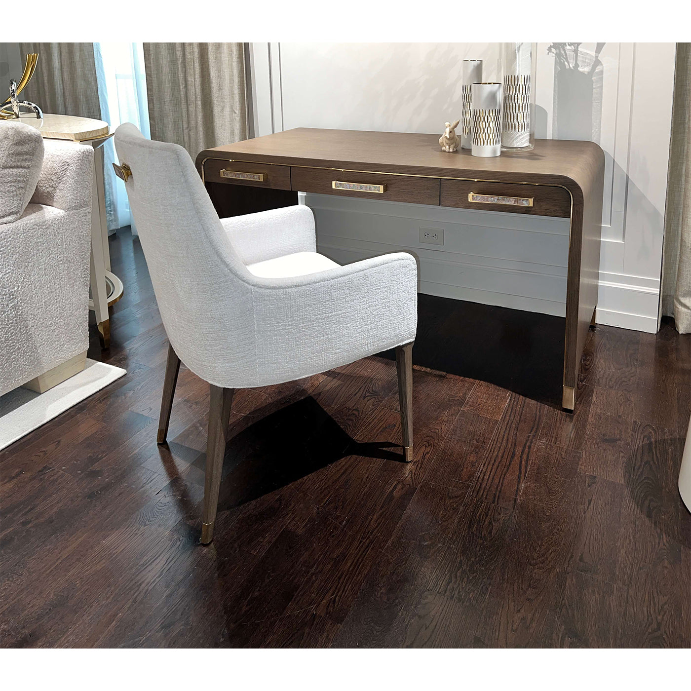 Desk and chair on dark wooden floor, room interior setup.
