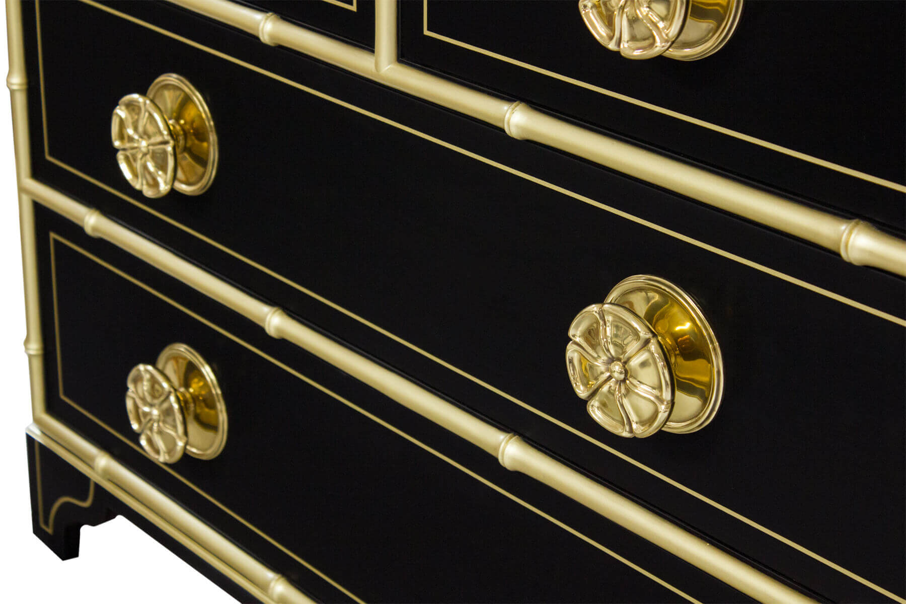 Close-up of black dresser with gold knobs.