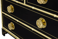 Close-up of black dresser with gold knobs.