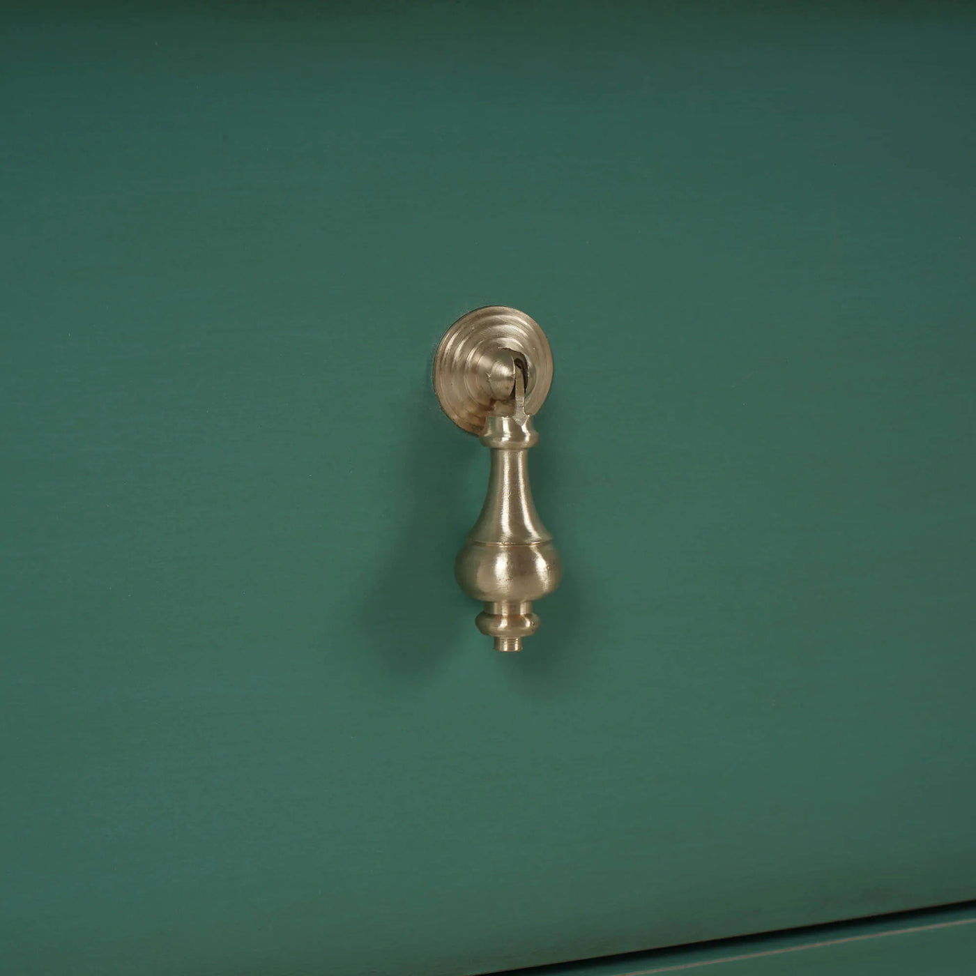 Detailed view of vintage dresser handle design.