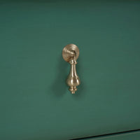 Detailed view of vintage dresser handle design.