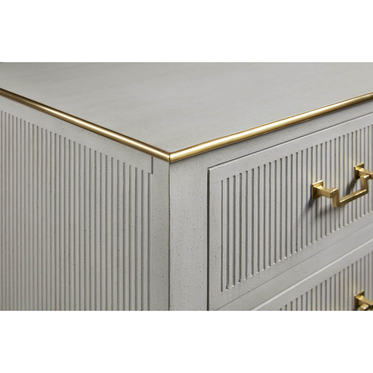 Close-up of bedside chest corner detailing with gold trim.