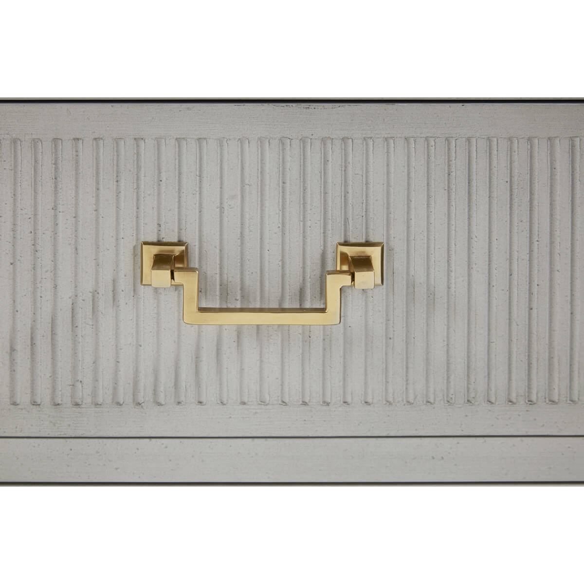 Close-up of gold handle on bedside chest.