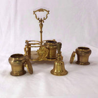 Disassembled parts of brass Standish on display.