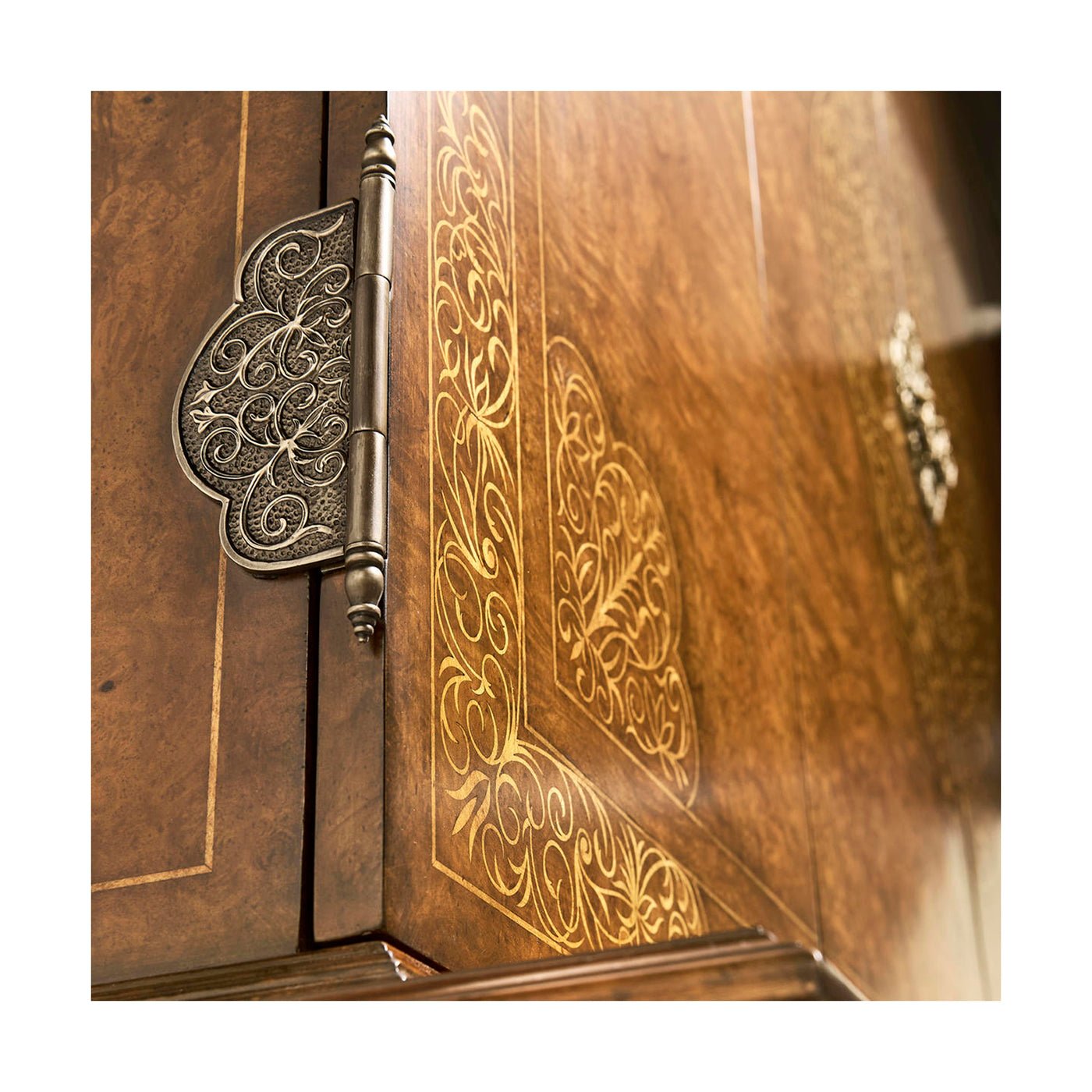 Close-up of ornate hinges on antique style TV cabinet.
