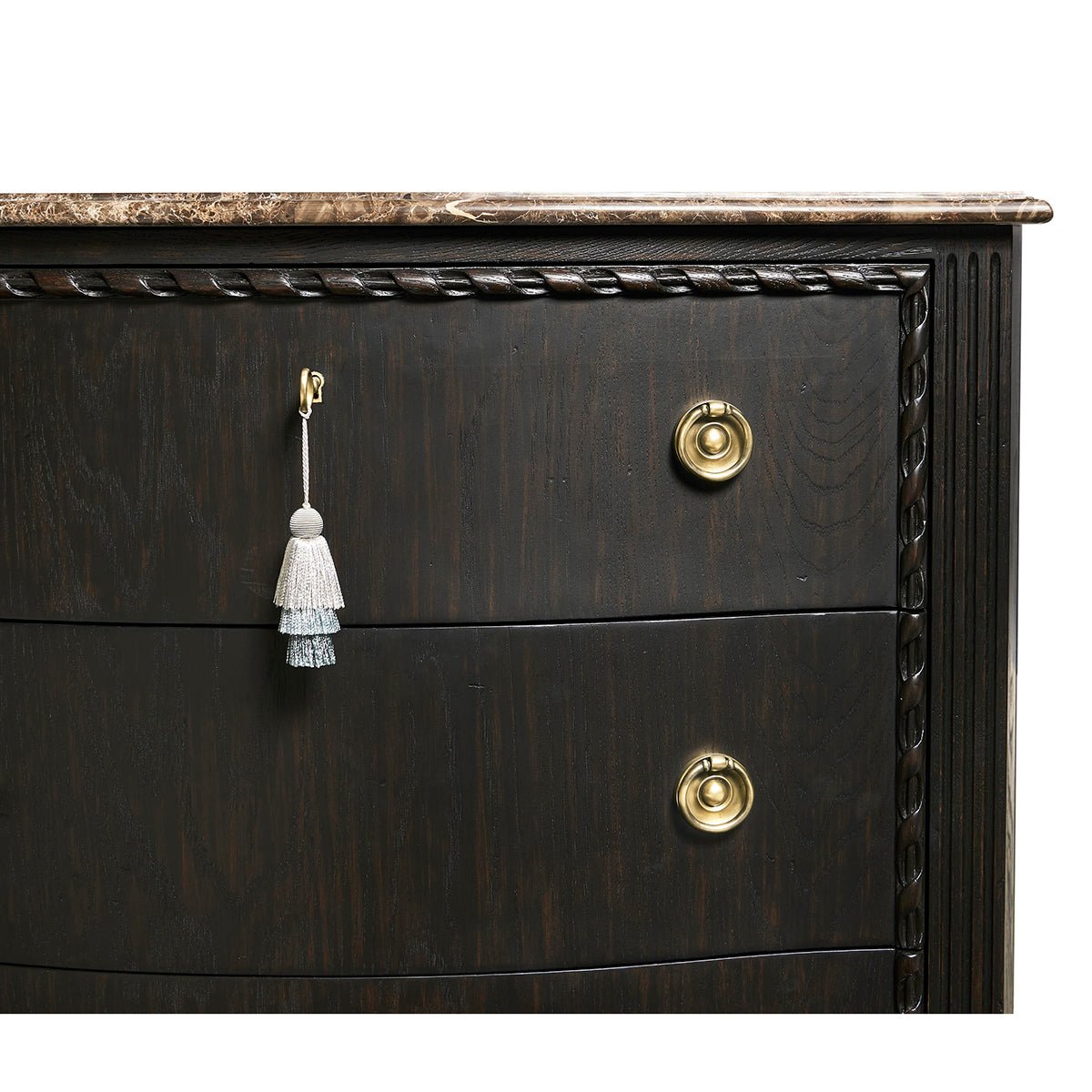 Brass hardware and tassel on ebonized marble chest.