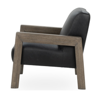 Side view of the black leather accent chair showing its angled back and open wood frame