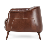 Side view of the Spiced Brown leather chair showing cream stitching and tapered legs