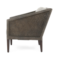 Side view of the gray rattan chair showing its woven panel and sloping arm