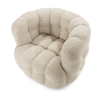 Elevated view of the beige swivel chair showing its tufted seat and curved arms