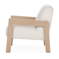 Side view of the Ivory chair with a sloping upholstered back and open oak frame