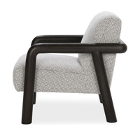 Side view of the accent chair showing its curved dark wood arms and angled back