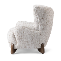 Side view of the Canvas Oat chair's wingback profile and shaped ash feet