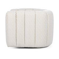 Rear view of the cream swivel chair with vertical channels around its curved back
