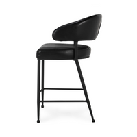 Side profile of the fluted black leather counter stool, showing the open space between back and seat