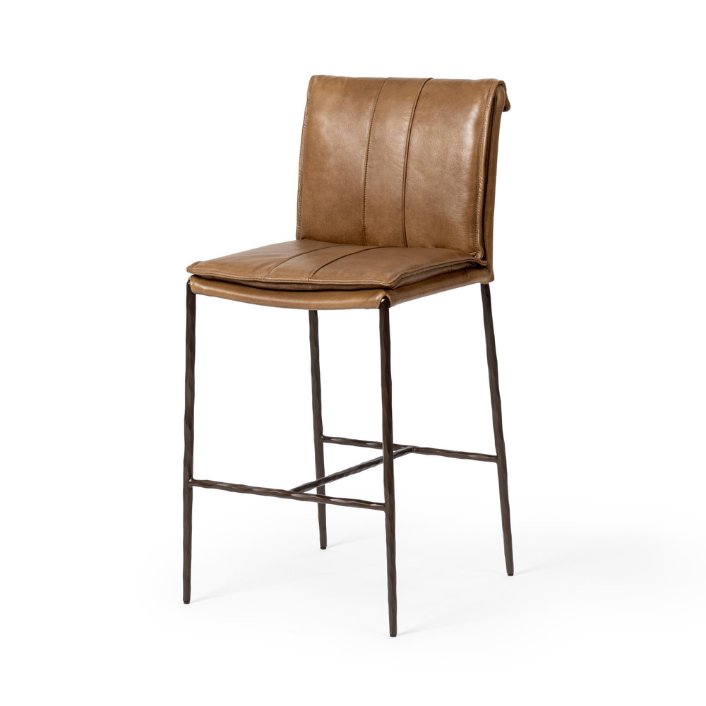 Slim-frame tan leather counter stool in a three-quarter front view, showing the stitched seat and slender iron legs