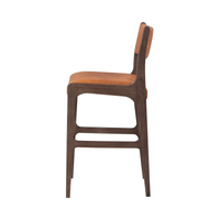 Side view of the cognac leather bar stool showing its curved ash frame and built-in footrest