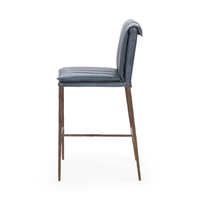 Side profile of the slim-frame blue leather counter stool, showing the rolled back and slender iron legs
