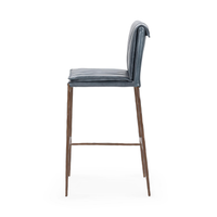 Side profile of the slim-frame blue leather bar stool, showing the rolled back and slender iron legs