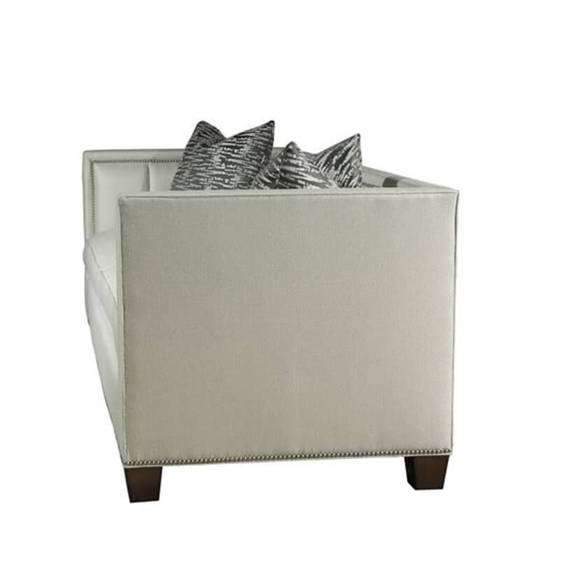 Side view of plush channeled sofa with pillows.