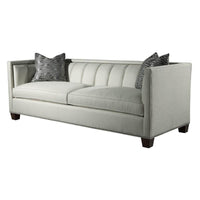 Plush channeled sofa with decorative pillows, angle view.