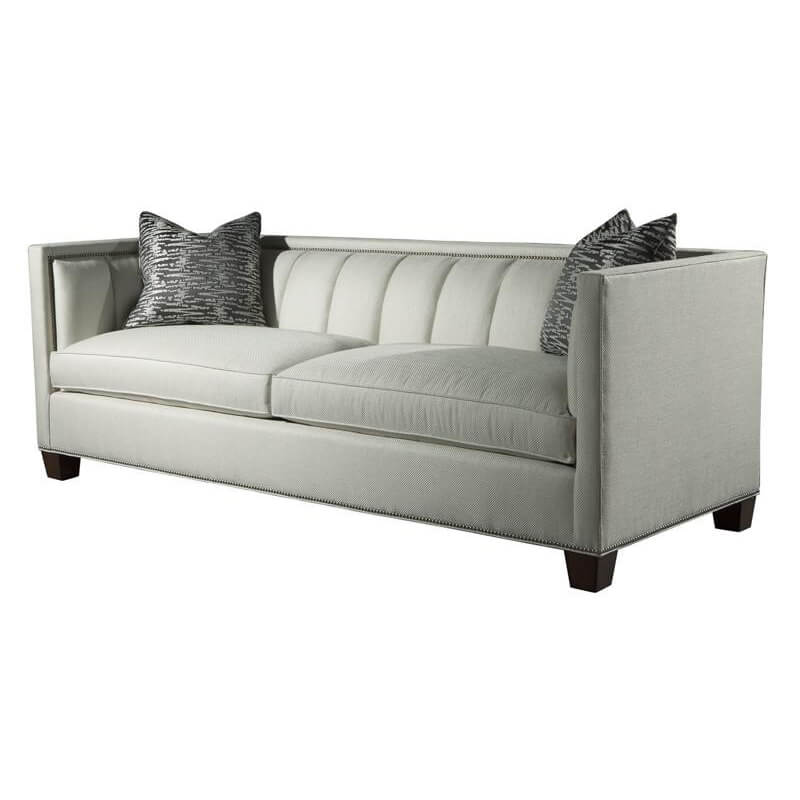 Plush channeled sofa with decorative pillows, angle view.