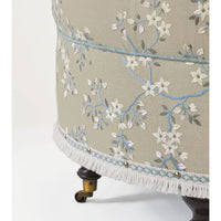 Detailed embroidery on poof, fringe trim, close-up.