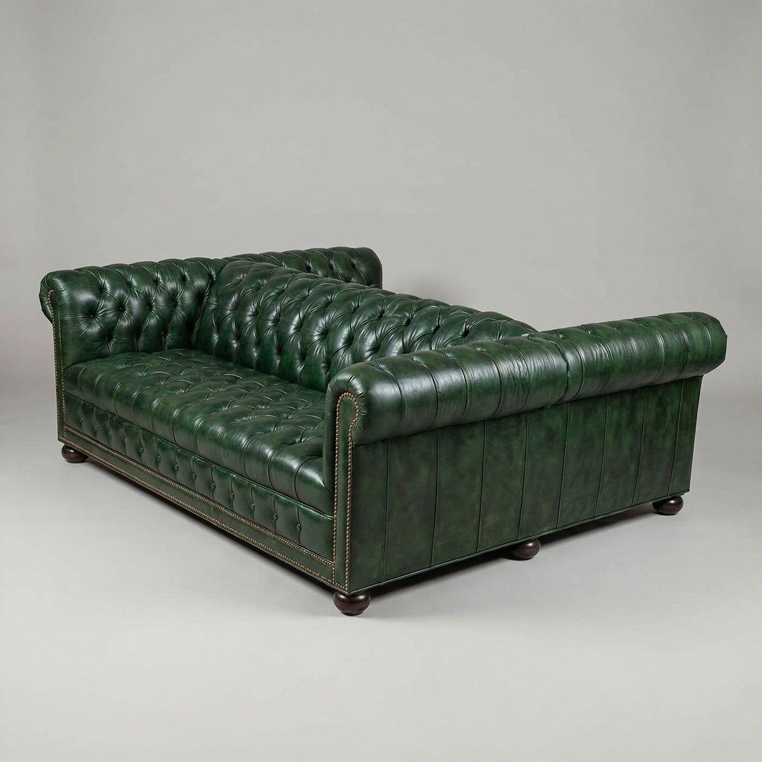 Double-sided Chesterfield sofa, green leather, angled back view.