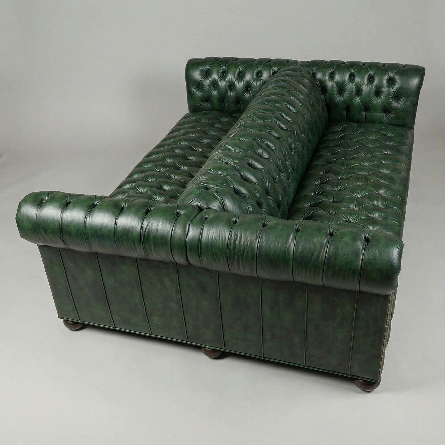 Green leather Chesterfield sofa, top view, button-tufted detail.