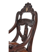 Close-up of armchair backrest with intricate carving.