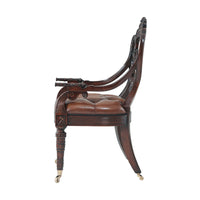 Side view of armchair with decorative wood carvings.