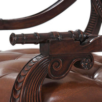 Close-up of cannon design on armchair armrest.