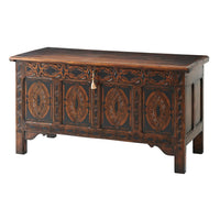 Closed English blanket chest with intricate carvings.
