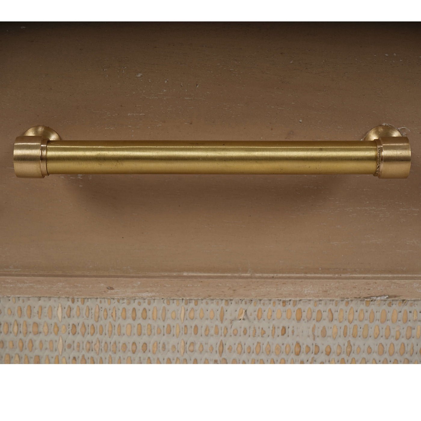 Close-up of chest of drawers brass handle design.