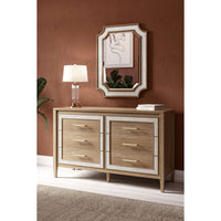 Modern dresser in room with mirror and lamp above.