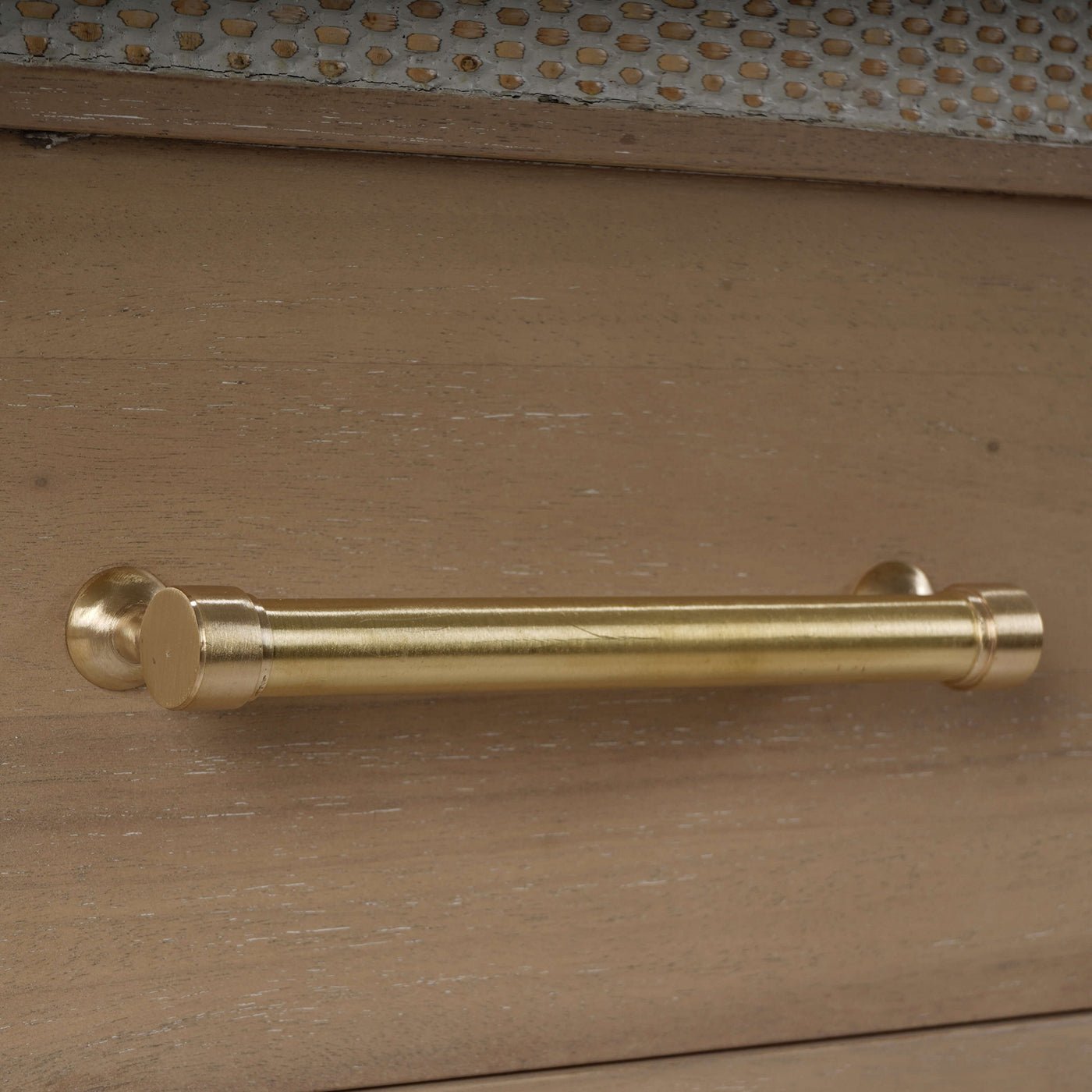 Close-up of the gold handle on wooden dresser.