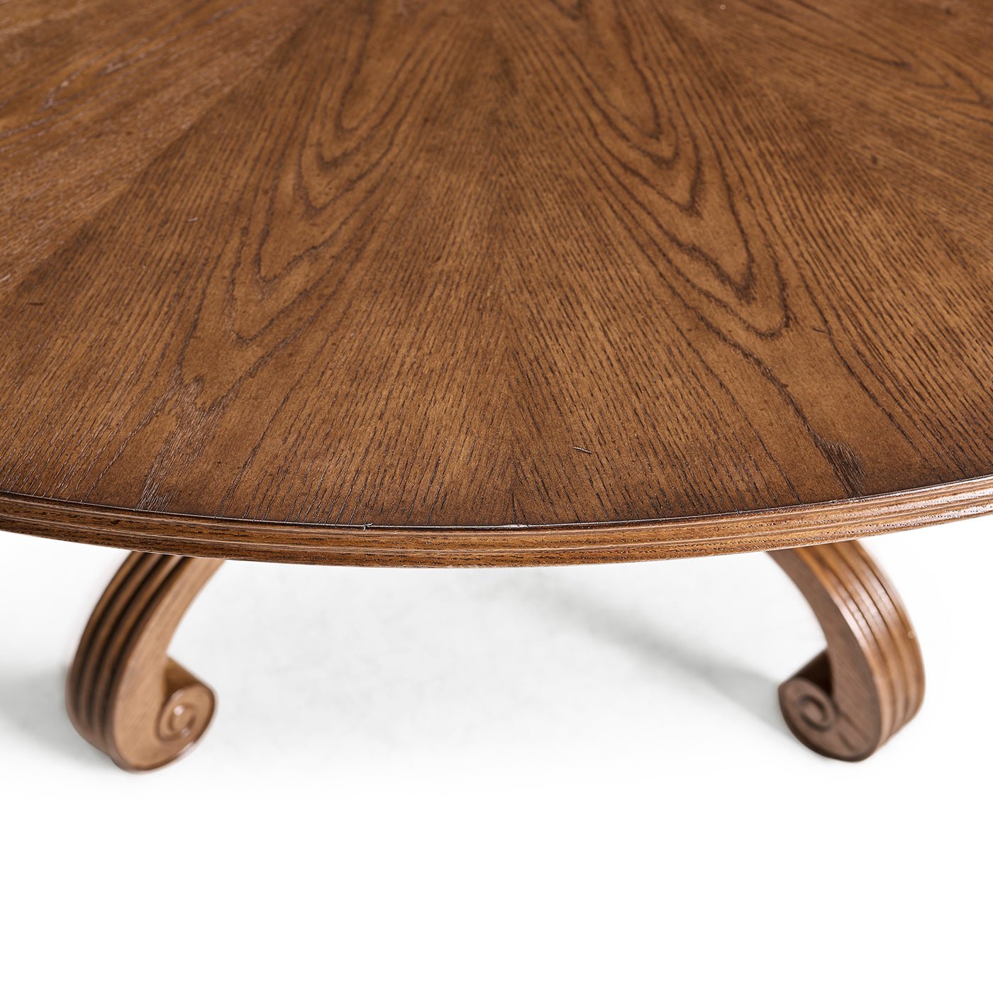 Close view of oak dining table edge and scroll legs.